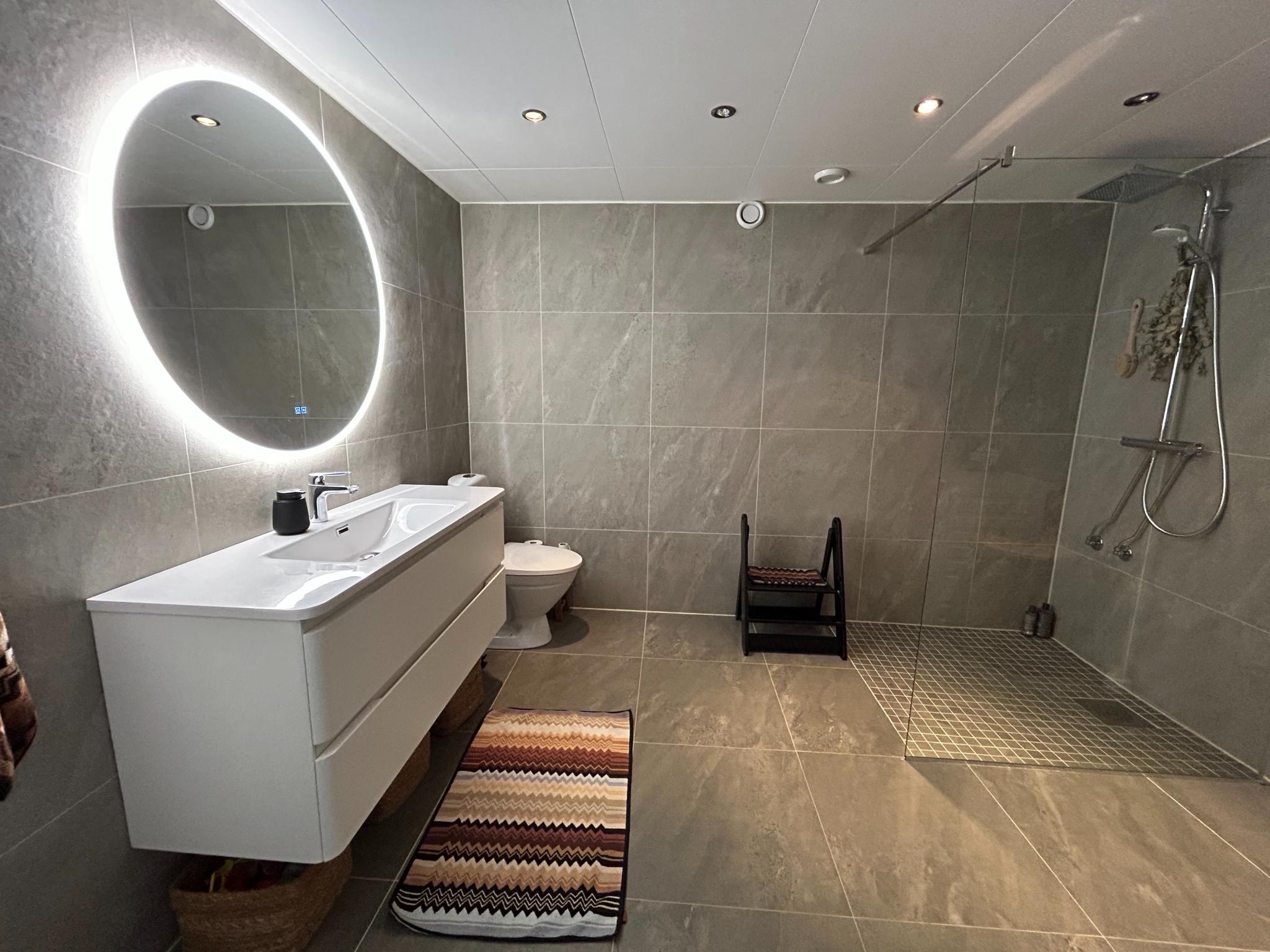 Ny oppusset bad i 2025 med stor dusj nisje og opplegg for vaskemaskin og tørketrommel.